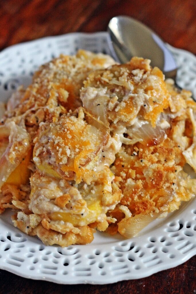 Close up of cheesy casserole with visible cheesy crumb topping plated with spoon.