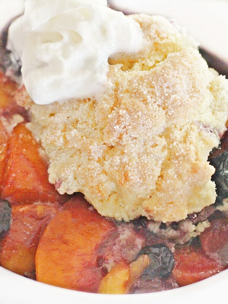 TikTok Peach Blueberry Cobbler baked until bubbling and topped with whipped cream.