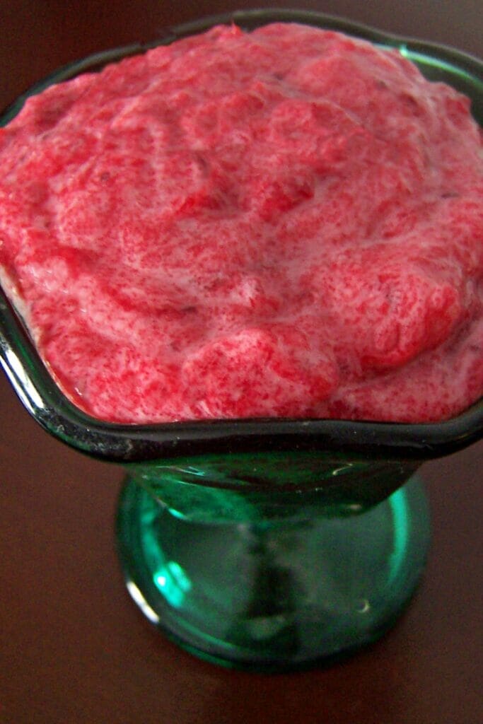 Ruby red cranberry butter in a jade green dessert glass.