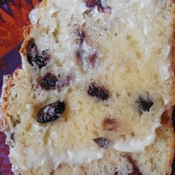 Image of a warmed and buttered slice of Sweet Cranberry Irish Soda Bread on a colorful plate.